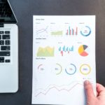 person holding chart and bar graph